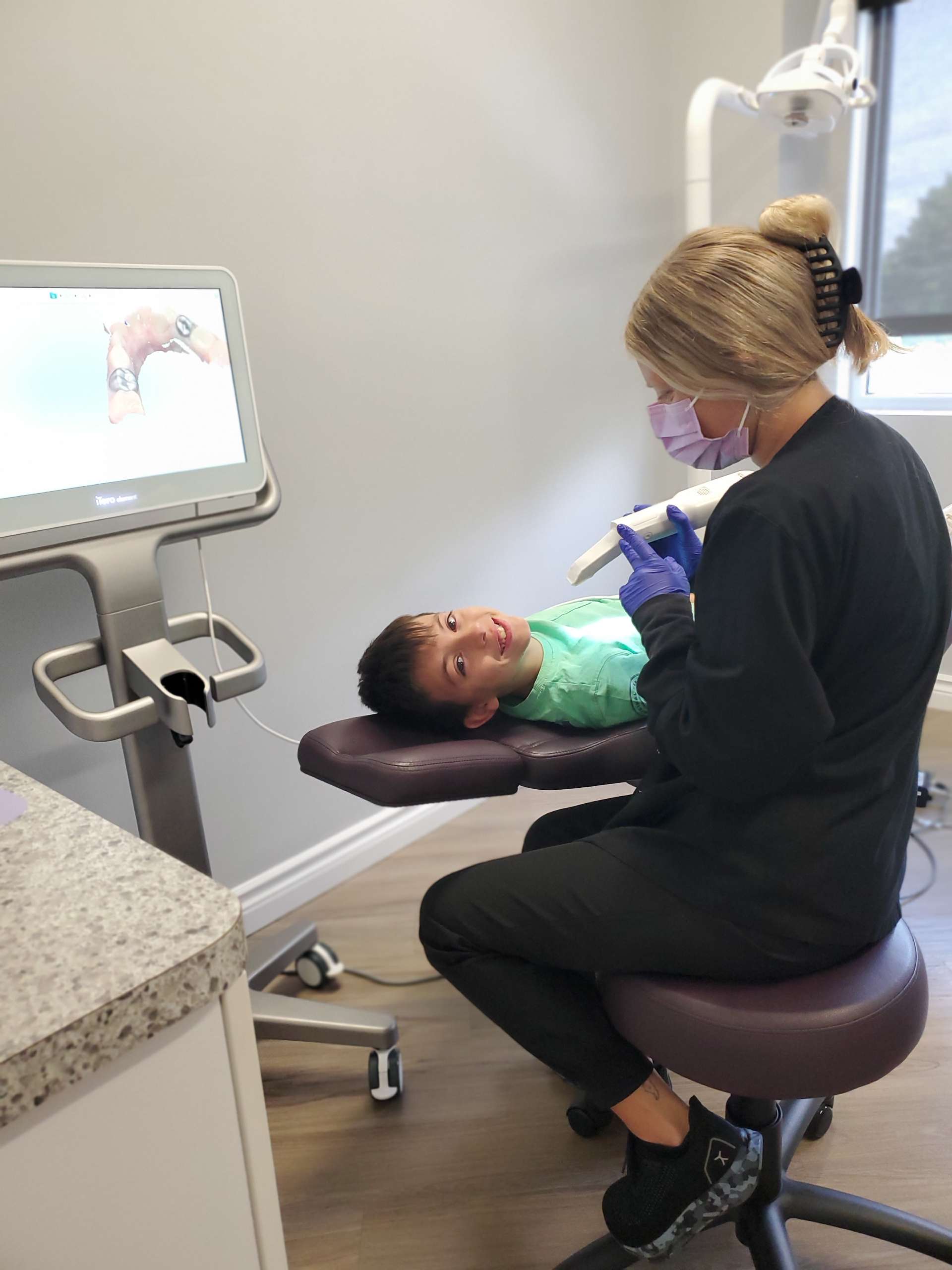 A happy child smiling while reclining in an orthodontic chair.