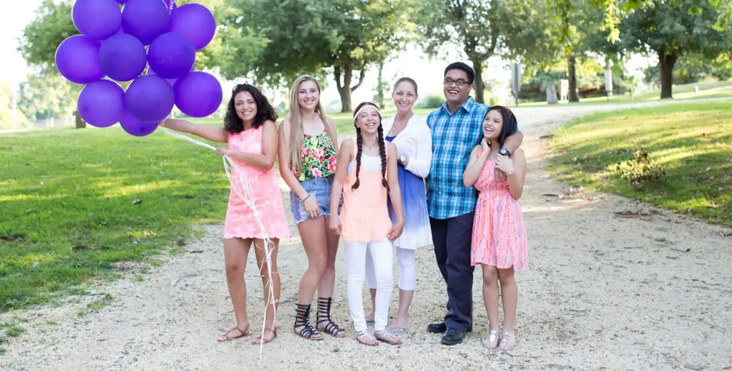 A happy family posing with their orthodontist, all smiling brightly together.