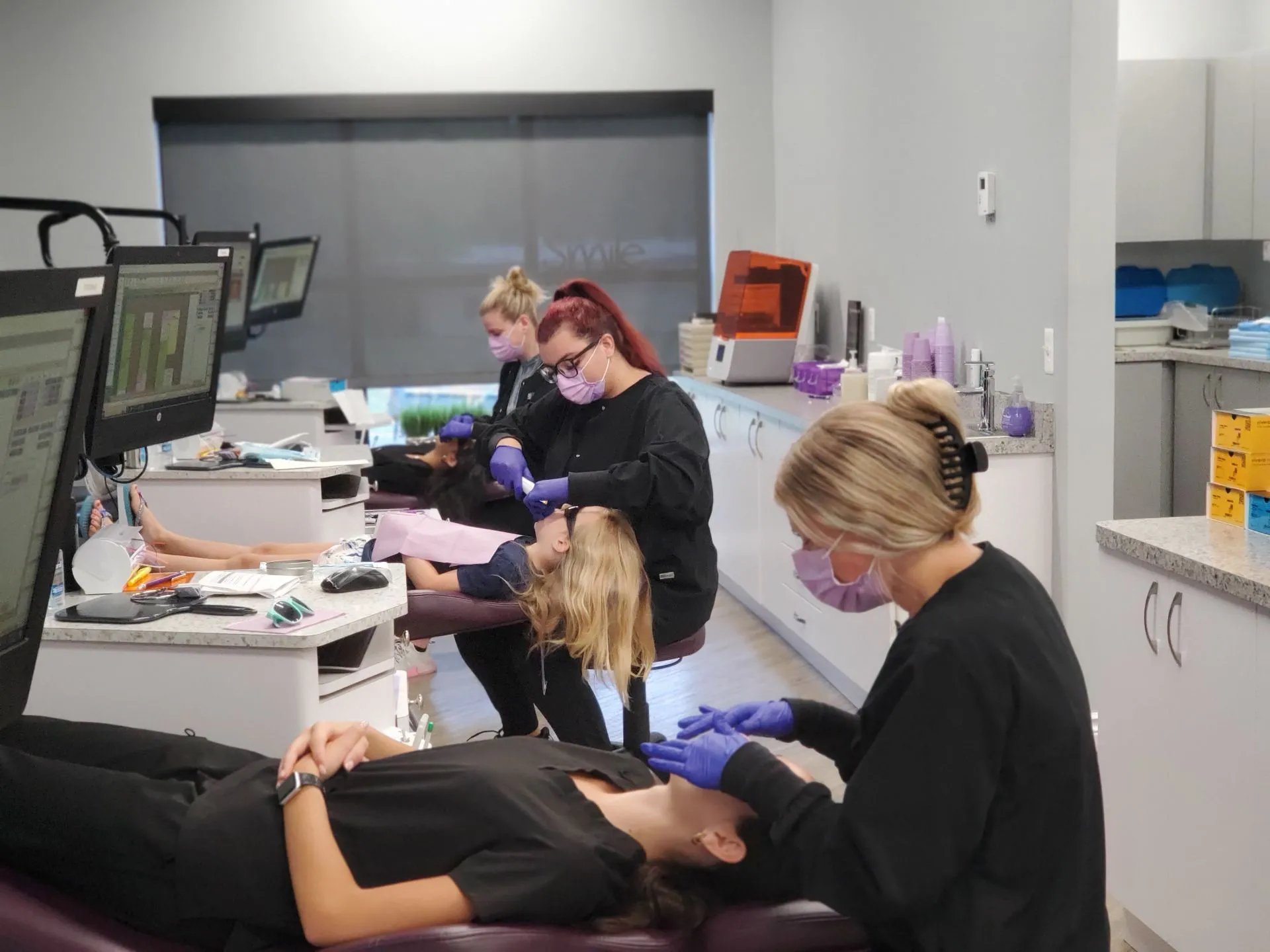 Orthodontic team members working together in a modern treatment room