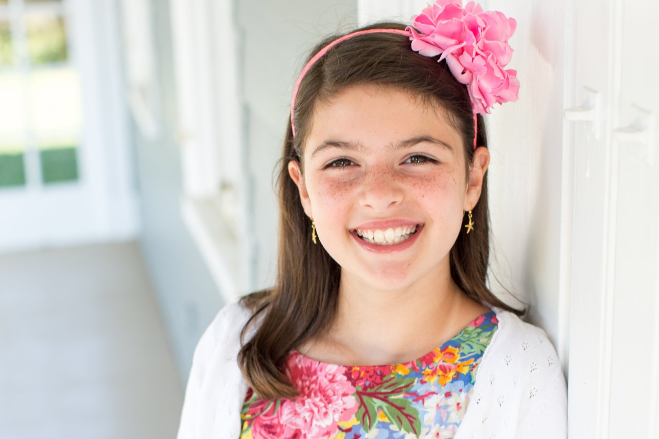 A young girl with freckles smiling brightly.