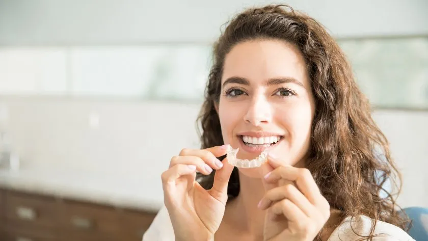Young woman about to insert her clear aligners, a daily routine with Invisalign for adults