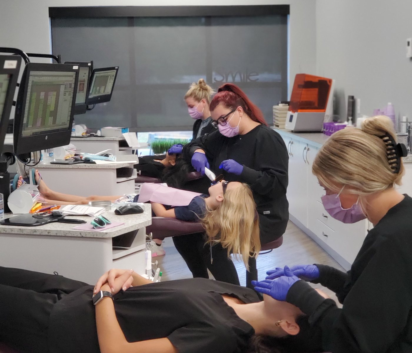 Three dental techs collaborating in the Marlboro location of TG Orthodontics.